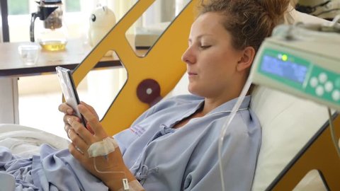 Woman Using Smart Phone in Hospital Bed
