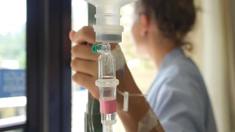 Female Patient with IV Infusion Bottle in Hospital