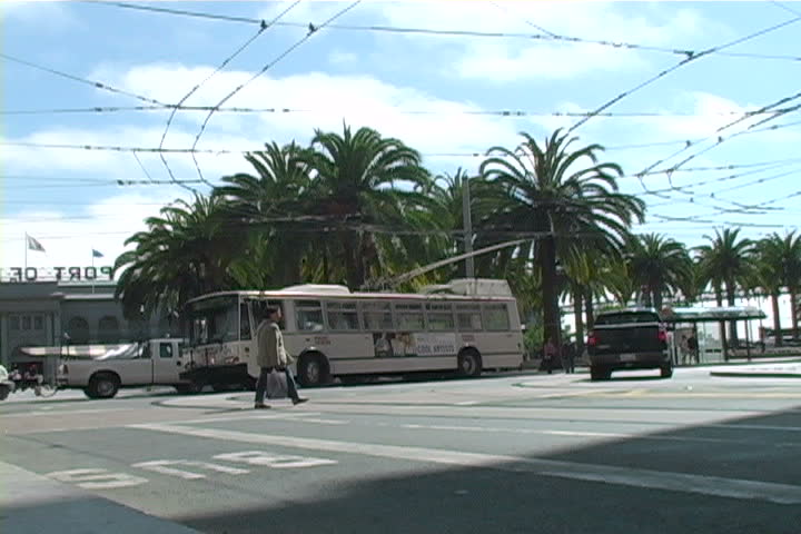 An electric bus making a turn in downtown San Francisco.