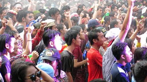 Bangkok, Thailand-April 15, 2014: People wave hands and watch a free concert at an outdoor place in the Siam area during Songkran  (Thai New Year) in Bangkok. People play water and watch the concert. 