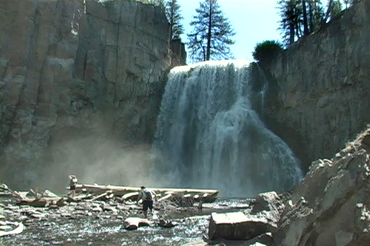 Two hikers getting a close-up view of Rainbow Falls.