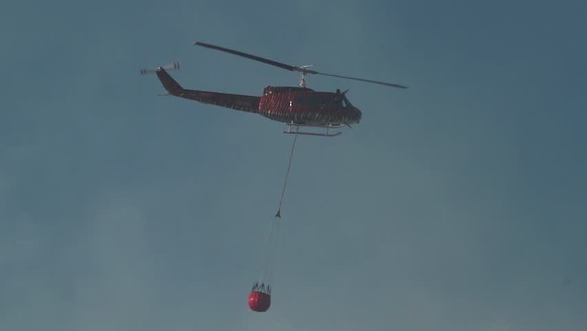 Fire fighting helicopter douses forest fire.Cape Town