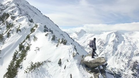 Young Man Standing On Top Of Rock Peak Looking At Nature Outdoors Inspiration Success Achievement Aerial Drone Hiker Looking At Winter Scenery