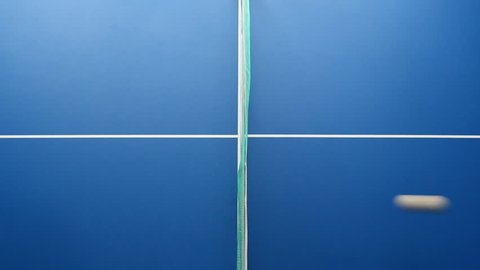Table tennis or ping pong ball, net and blue table above close up view