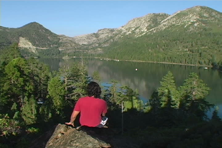 A man taking in the view of Emerald Bay at sunrise.