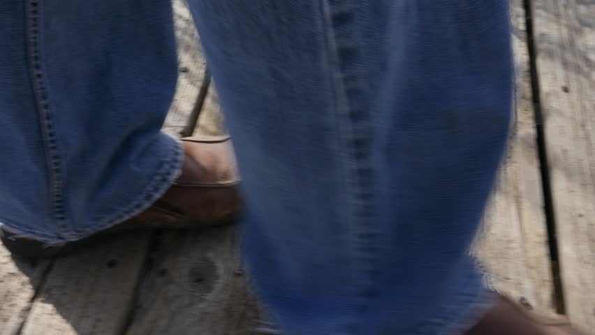 A gimbal shot of a man walking on a boardwalk hiking trail