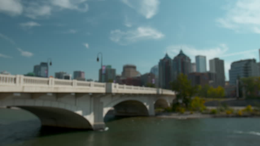 Shot of the Calgary skyline/downtown from across the Bow river with the river in the foreground.  Has the Louise Riley bridge in the foreground as well.  Shot in early autumn.