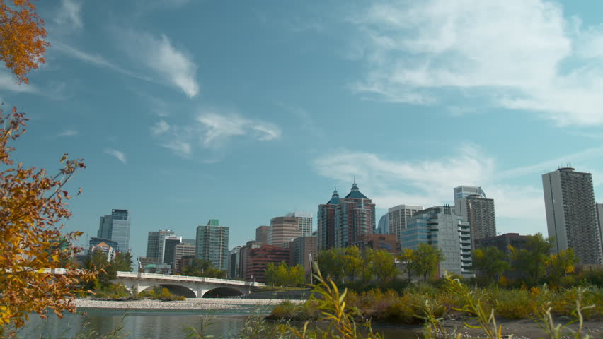 Shot of the Calgary skyline/downtown from across the Bow river with the river in the foreground.  Has the Louise Riley bridge in the foreground as well.  Shot in early autumn.