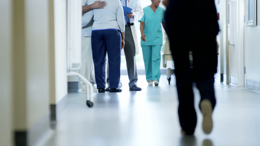 Busy staff of hospital on corridor and male doctor consult with senior patient Royalty-Free Stock Footage #14611060