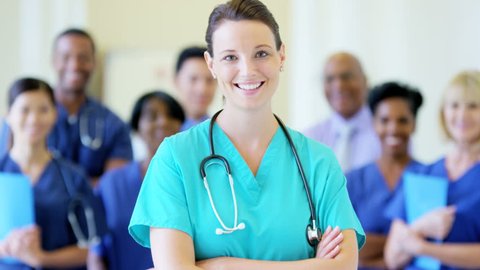 Portrait of confident Caucasian young female nurse and team of staff in hospital