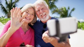 Mature Caucasian couple on Caribbean beach taking a selfie