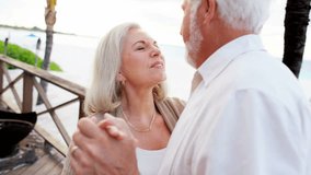 Mature Caucasian couple dancing on a tropical vacation - Powered by Shutterstock - Get 15% off with code: PIKWIZARD15