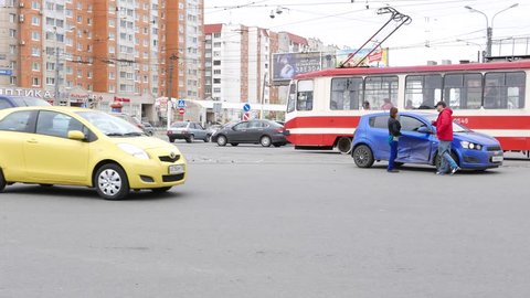 SAINT-PETERSBURG, UNITED ARAB EMIRATES - MAY 11, 2015: Car accident on busy road junction, unidentified driver take pictures of vehicle damages. Daytime, lively traffic, auto pass on fore and back