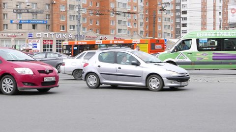 SAINT-PETERSBURG, RUSSIA - MAY 11, 2015: Side view of damaged car in middle of lively road intersection, front bumper fall down. Car crash aftermath. Unidentified woman in orange vest talk on phone