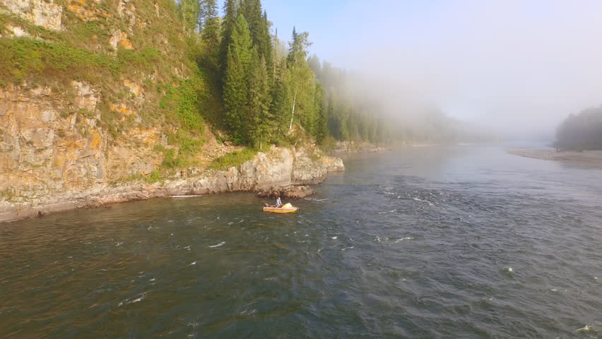Aerial: Boat floats on the river. Top view. Landscape panorama. Altai, Siberia. DJI Phantom Drone. 
