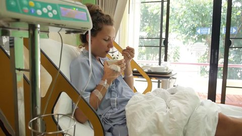 Sick Female Patient Eating Soup in Hospital Room