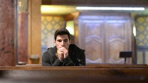 Young man praying in church