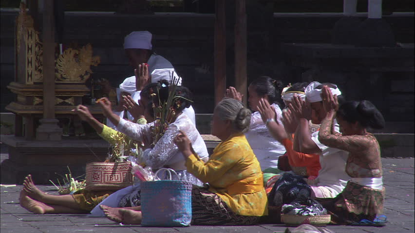Balinese Women Making Offerings and Praying At Temple