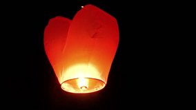 Traditional. Asian flying lantern. powered by the hot air rising from a burning oil wick. ascending slowly into the tropical night sky. FullHD video