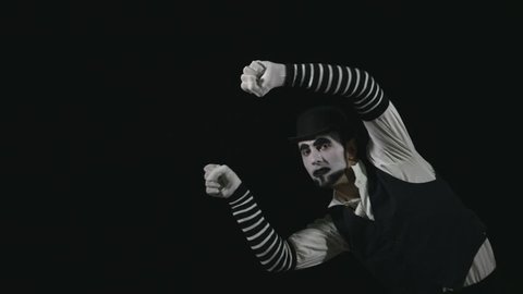 Young funny mime performing a invisible wall act