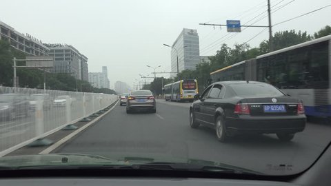 BEIJING - 4 SEPTEMBER 2015: A taxi drives across a ringroad in Beijing on a grey and smoggy day