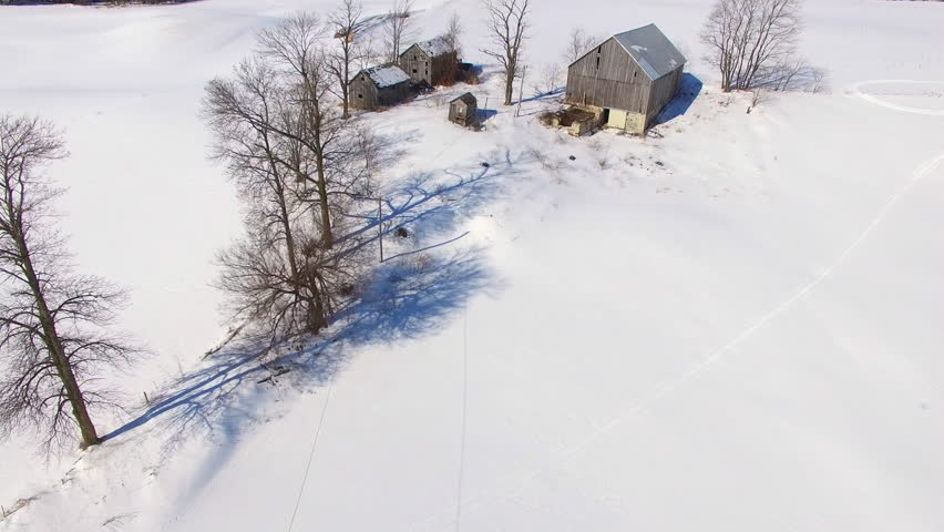Scenic Winter flyover of rustic, abandoned farm buildings in rural Wisconsin.
