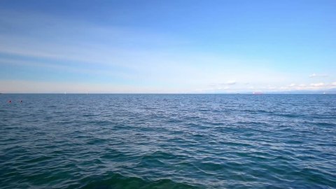 Sea view on the nice summer day: blue sky with small clouds, clean blue sea water and smooth waves,  clear horizon line. Sea, ocean, nature video background for touristic and resort websites. 