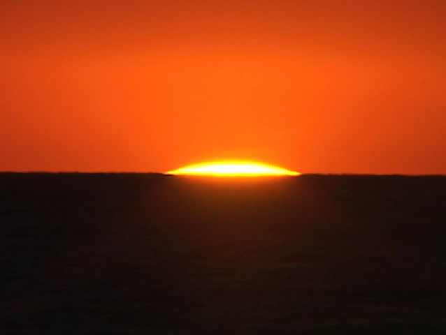 A blazing sun sits on the horizon.
