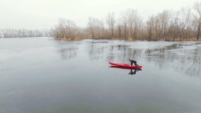 Aerial view of athlete rowing in a kayak. Winter. Ice