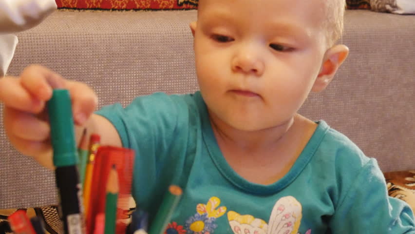 a child plays with crayons