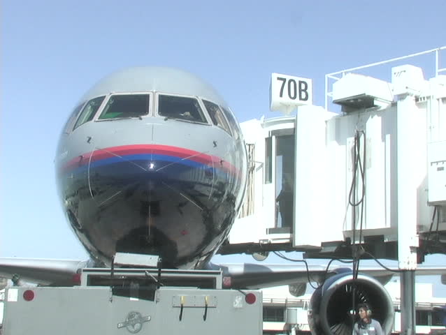 A passenger loading dock pulls away from a jet.
