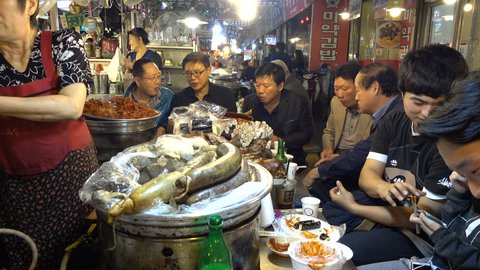 SEOUL, SOUTH KOREA - 8 OCTOBER 2015: People get together to eat dinner in a popular night food market in Seoul city, South Korea