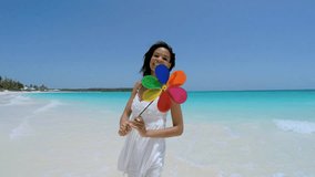 Selfie portrait smiling African American girl holding toy pinwheel on beach