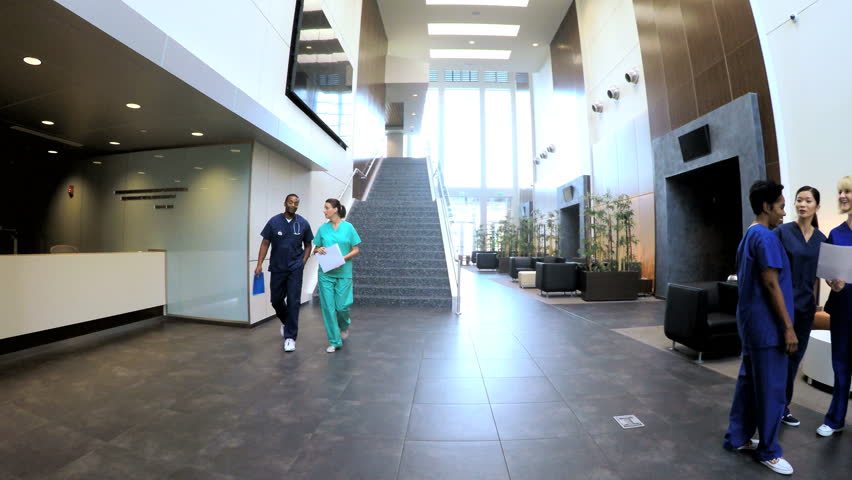 Multi ethnic professional staff wearing scrubs in medical center reception Royalty-Free Stock Footage #14691730