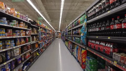 MONTREAL, CANADA - FEBRUARY 2016: Slow Motion: Walking through Walmart aisle (Chips, snacks, soda drinks & fast food)