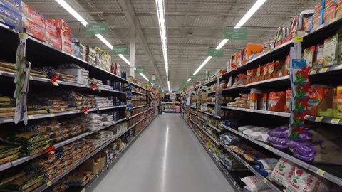 MONTREAL, CANADA - FEBRUARY 2016: Slow Motion: Walking through Walmart aisle (BBQ ingredients, ketchup, mayo, oils, food cans, sauces etc.)
