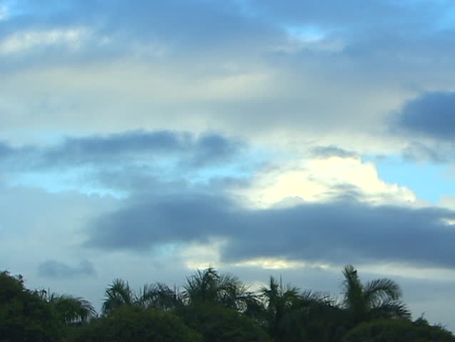 Broad horizontal bands of different shades of blue and gray across the sky above a lake hint of an incoming storm.