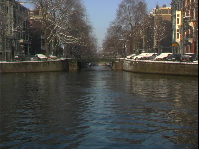 A water taxi travels through a canal in Amsterdam.