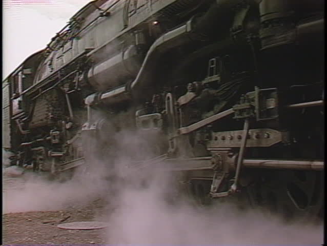 Close-up of steam coming from the front of a locomotive as it begins to move.