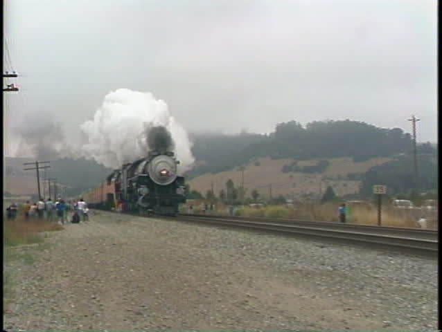 Pan-right shot of a vintage Southern Pacific passenger train passing by fast.