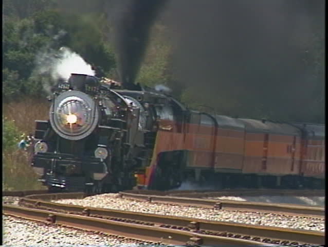 Tracking shot of a Southern Pacific steam passenger train rounding a bend in California.