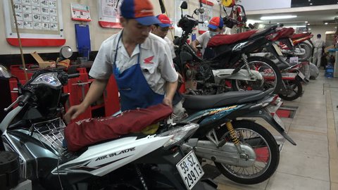 HO CHI MINH CITY, VIETNAM - 4 DECEMBER 2015: Motorcycle repair center, workers in a Honda service station (garage) in Ho Chi Minh City (Saigon) in Vietnam