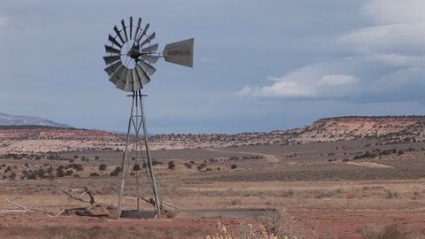 Medium shot of an old windmill standing on a desert plain.