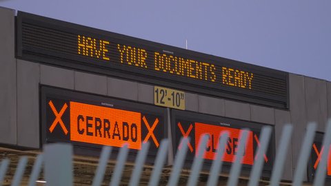 A lit up sign at the border that says, "HAVE YOUR DOCUMENTS READY." to help people migrate between countries.
