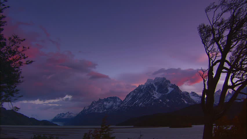 Pink and Purple Dusk Settles Over Snow Covered Mountains and Lake In Patagonia,