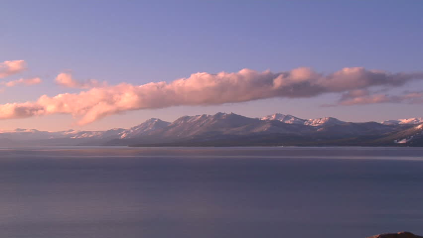 Pink Sunlit Clouds Rolling Over Lake Tahoe and Surrounding Snow Capped