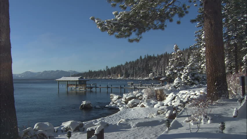 Snow Covered Lake Shore With Private Dock And Blue Skies