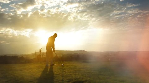 Golf Player plays golf on a beautiful summer morning. Backlite shot