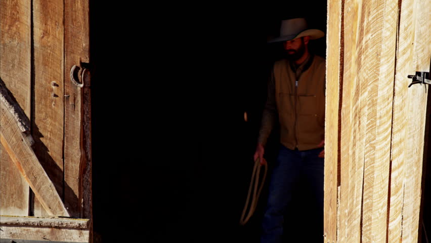 Cowboy Ranch hand with horse on Dude Ranch in Corral Canada
