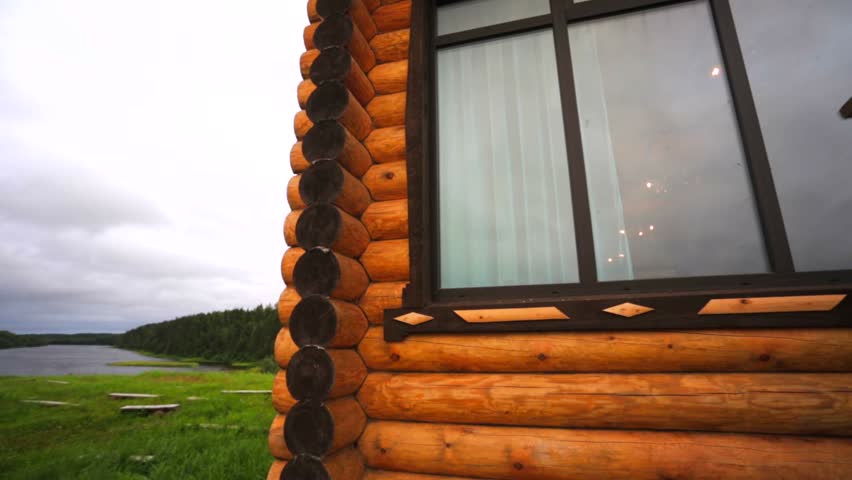 View of meadow, river and two new build wooden houses.